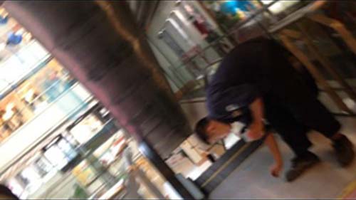 一名電梯維保人員把螺絲補回扶梯踏板的螺絲孔
