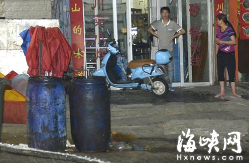 小吃店把泔水桶放在路邊等待回收