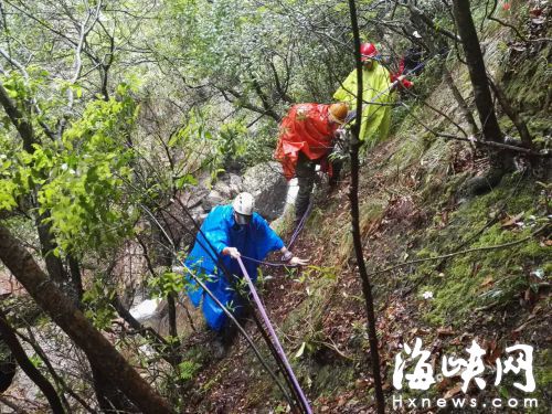 山高林密，地形復(fù)雜，救援人員借助繩索進山搜救