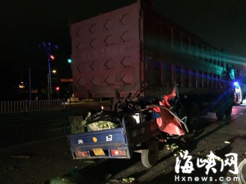 運(yùn)菜的電動(dòng)三輪車，車頭卡在貨車后
