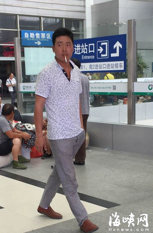 昨日上午,火車站,一名乘客抽著煙走在售票大廳里