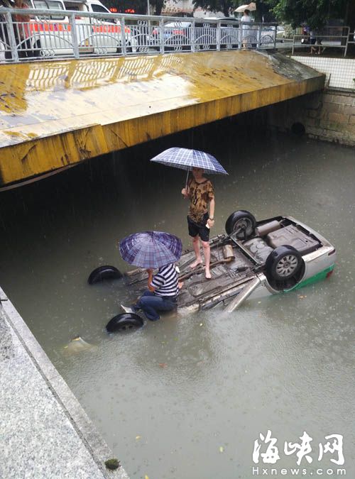 司機和乘客撐著傘被困河中 