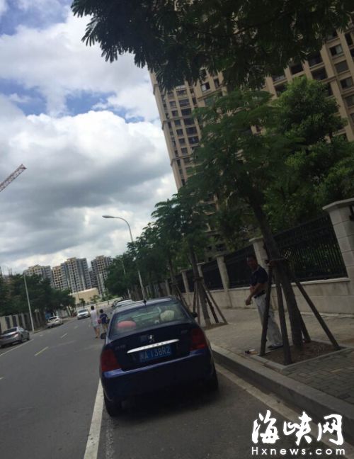 非機動車道上停滿車輛，一男子站在旁邊收費