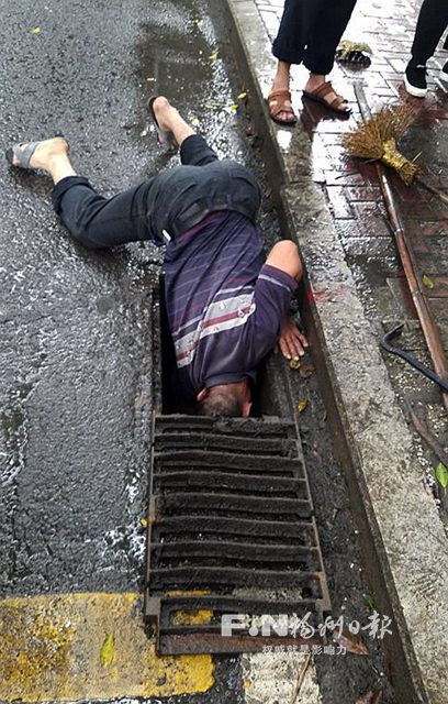 環衛工雨中“埋頭”疏通下水道　市民：令人感動