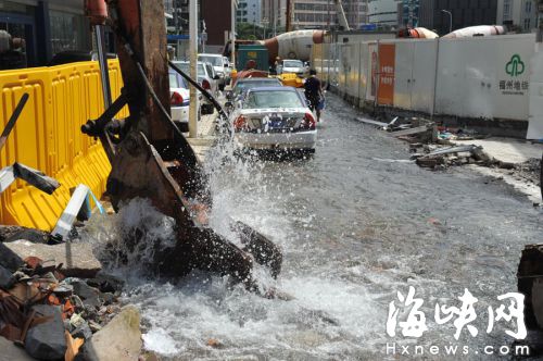“肇事”的破碎機壓在水管破洞口，百余米道路成河