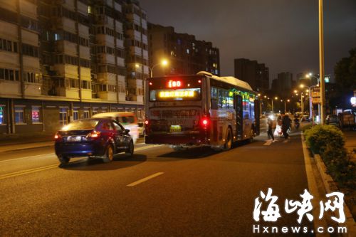 金山盧濱路金山公交總站公交站路段，公交車(chē)停在僅有兩個(gè)車(chē)道的路中間上下客，后面的小車(chē)壓黃線繞過(guò)